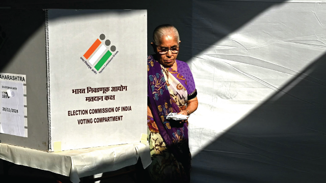 A voter leaves the polling booth after casting her ballot in state assembly elections in Mumbai, India, on Nov. 20, 2024. (Photo by Indranil Mukherjee/AFP via Getty Images)